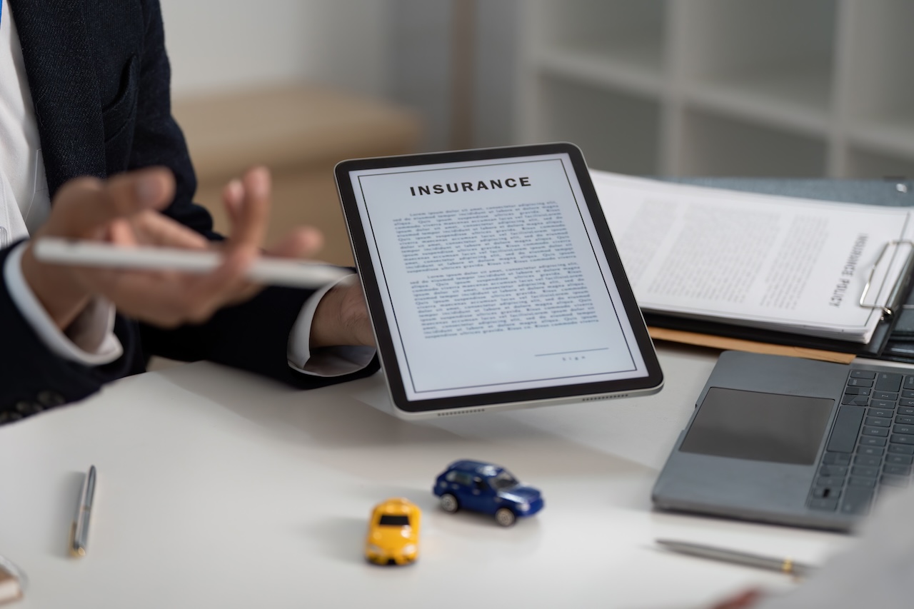 man holding insurance contract via tablet